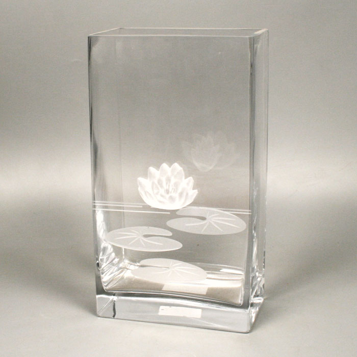 Вазон Deco-Glass, высота 27 смАС 04119/0270/АА-U0108 Вазон Deco-Glass, высота 27 смАС 04119/0270/АА-U0108Элегантный вазон Deco-Glass изготовлен из прозрачного стекла и декорирован объемной матовой лилией с рельефными листьями. Эксклюзивный вазон подчеркнет оригинальность интерьера и прекрасный вкус хозяина. Создайте в своем доме атмосферу уюта, преображая интерьер стильными, радующими глаза предметами. Также вазон может стать хорошим подарком вашим друзьям и близким. Характеристики:Материал:стекло. Размер вазона: 15 см х 8,5 см х 27 см. Размер упаковки: 16,5 см х 10 см х 29 см. Артикул: АС 04119/0270/АА-U0108.