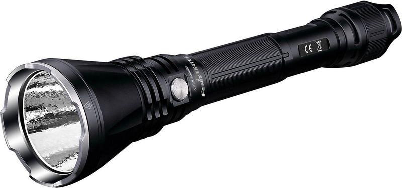 Фонарь ручной Fenix TK47UE, цвет: черныйTK47UE Фонарь ручной Fenix TK47UE, цвет: черныйTK47UEОписание фонаря Fenix ТК47UE:Многофункциональный и современный в плане технической «начинки» фонарь Fenix TK47UE ориентирован на решение самых различных задач. В него интегрировано сразу три диода, которые распределены между двумя автономными узлами. Оба узла можно включать одновременно или же поочередно. Для этого предназначены две кнопки: по одной на каждый из узлов. Помимо того, включение основного и более яркого диода можно заблокировать, чтобы предотвратить случайную разрядку аккумуляторов.Главный диод — это представитель семейства Cree, а именно - XHP70. Он известен как яркостью (до 3200 люмен), так и долговечностью (50 000 часов). Этот диод размещается в текстурированном рефлекторе, что позволяет получить плотный центральный пучок света с углом 10°, равномерно переходящий в радиальную засветку. Он дает возможность использовать шесть режимов освещения. Как уже говорилось, максимальная яркость Fenix TK47UE — 3200 люмен. Она доступна в режиме Turbo, который в состоянии поддерживаться 1 час. Свет в этом режиме распространяется на 408 метров За ним следует режим High с пределом яркости — 1000 люмен. Запаса аккумуляторов хватит на его поддержание в течение 3 часов 20 минут. Радиус видимости — 232 метра. Средний по яркости режим – Med. Его яркость — 350 люмен при дальности луча 130 метров, а длительность использования — 11 часов 20 минут. Режим низкой яркости — Low — дает ровно 100 люмен света и остается доступным в течение 46 часов. Радиус луча — 69 метров. Самый экономный для этого диода режим — Low. Его яркость — 100 люмен. Фонарь будет работать в течение 170 часов и светить вдаль на 31 метр. В дополнение к перечисленным, доступен режим стробоскопа с яркостью вспышек 3200 люмен.Необычным в конструкции модели TK47UE является то, что второй источник света располагается с обратной стороны — в хвосте фонаря. Это два не столь ярких светодиода, как предыдущий, которые светят сквозь диффузор, давая мягкий свет. Один из них — белый, а второй — красный. Белый диод работает лишь в одном режиме — постоянного света с яркостью 30 люмен. Запаса энергии аккумуляторов достаточно для поддержания его работы в течение 43 с половиной часов. Красному диоду доступно 3 режима: Red light, Red SOS, Red flash. Каждый из них дает яркость в 1,5 люмена.Важным уточнением является то, что указанная выше продолжительность работы высчитана с учетом установки в Fenix TK47UE двух аккумуляторов Fenix емкостью по 3500 мАч. Пользователи могут выбрать иные аккумуляторы или же батарейки CR123A, но тогда продолжительность работы будет отличаться от указанной.Фонарь Fenix TK47UE укомплектован несколькими защитными механизмами, которые делают его работу более стабильной и продолжительной. В том числе, это защита от коротких замыканий, перегревания при высокой яркости освещения, стабилизация напряжения, поступающего на диод. За механическую прочность данной модели отвечает алюминиевый корпус. Он подвергнут жесткому анодированию и сделан водонепроницаемым. Поэтому фонарь не пострадает после падения с полутораметровой высоты, сможет продолжать работать под дождем или даже в случае кратковременного погружения под воду целиком. Эта модель отлично подойдет для охотников, спасателей, туристов, а также станет отличным выбором во множестве других ситуаций.Особенности:фонарь с тремя встроенными диодами;два отдельно работающих оптических узла;установлен главный диод модели Cree XHP70;вспомогательное белое и красное освещение;фонарь работает в десяти режимах;пара кнопок для управления;предустановлена защита от перегревания;верхний предел яркости - 3200 люмен;размер центрального пятна света - 10°;полезная дальность светового потока - 408 метров;водонепроницаемый корпус из алюминия.Гарантия: Официальная гарантия сроком 5 лет предоставляется к каждой покупке фонаря Fenix TK47UE.