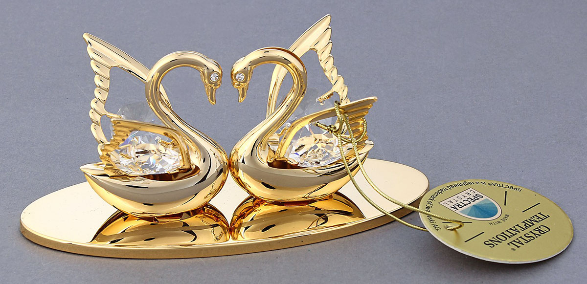 Миниатюра Swarovski Elements Два лебедя, на подставке, с кристаллами Сваровски, 4,5 х 10 х 4,5 см618921 Миниатюра Swarovski Elements Два лебедя, на подставке, с кристаллами Сваровски, 4,5 х 10 х 4,5 см618921Сувенирные лебеди станут идеальным подарком близкому человеку и всем любителям эксклюзивных вещей ручной работы. Они символизируют изящество, красоту, чистую и прекрасную любовь, супружескую верность и блаженство.Сувенир украшен стразами Swarovski, которые были признаны специалистами лучшей имитацией бриллиантов. Свет, попадая на кристаллы Swarovski, разбивается на миллион радужных лучей. Это зрелище, бесспорно, оставляет яркое впечатление!