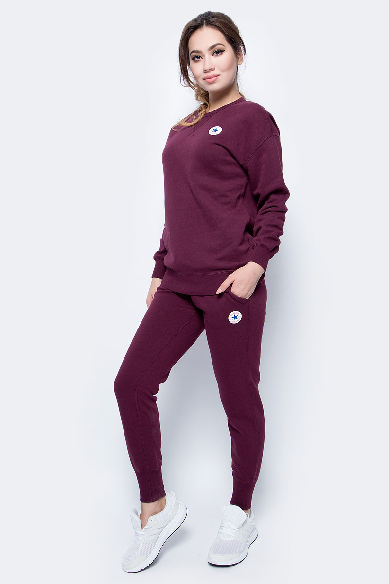 Брюки спортивные женские Converse Core Signature Pant, цвет: бордовый. 10004546262. Размер M (46)10004546262 Брюки спортивные женские Converse Core Signature Pant, цвет: бордовый. 10004546262. Размер M (46)10004546262Женские спортивные брюки изготовлены из качественного трикотажа на основе хлопка. Модель на широкой эластичной резинке и шнурке на талии дополнена боковыми карманами. Брючины снизу оформлены широкими резинками. Такие брюки незаменимая вещь в спортивном и летнем гардеробе. Прекрасный выбор для занятий фитнесом или активного отдыха.