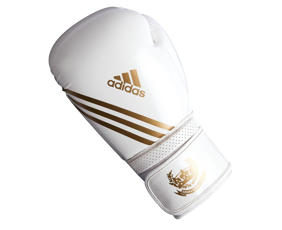 Перчатки боксерские Adidas Hybrid Aero Tech, цвет: бело-золотой. adiBL06. Вес 8 унцийAIRWHEEL M3-162.8 Перчатки боксерские Adidas Hybrid Aero Tech, цвет: бело-золотой. adiBL06. Вес 8 унцийAIRWHEEL M3-162.8Боксерские перчатки Adidas Hybrid Aero Tech изготовлены из полиуретана PU4G, который по своим качествам не уступает натуральной коже. Внутренний наполнитель из многослойной пены закрывает тыльную сторону и боковую часть ладони, обеспечивая надежную защиту рук боксера и позволяя безопасно тренироваться в полную силу. Загнутый параллельно кулаку большой палец обеспечивает безопасность при нанесении ударов и защищает большой палец от вывихов и травм. Вентиляционные отверстия на ладони создают максимальный уровень комфорта для рук, поддерживая оптимальный микроклимат внутри перчаток. Широкий ремень, охватывая запястье, полностью оборачивается вокруг манжеты, благодаря чему создается дополнительная защита лучезапястного сустава от травмирования. Застежка на липучке способствует быстрому и удобному одеванию перчаток, плотно фиксирует перчатки на руке.