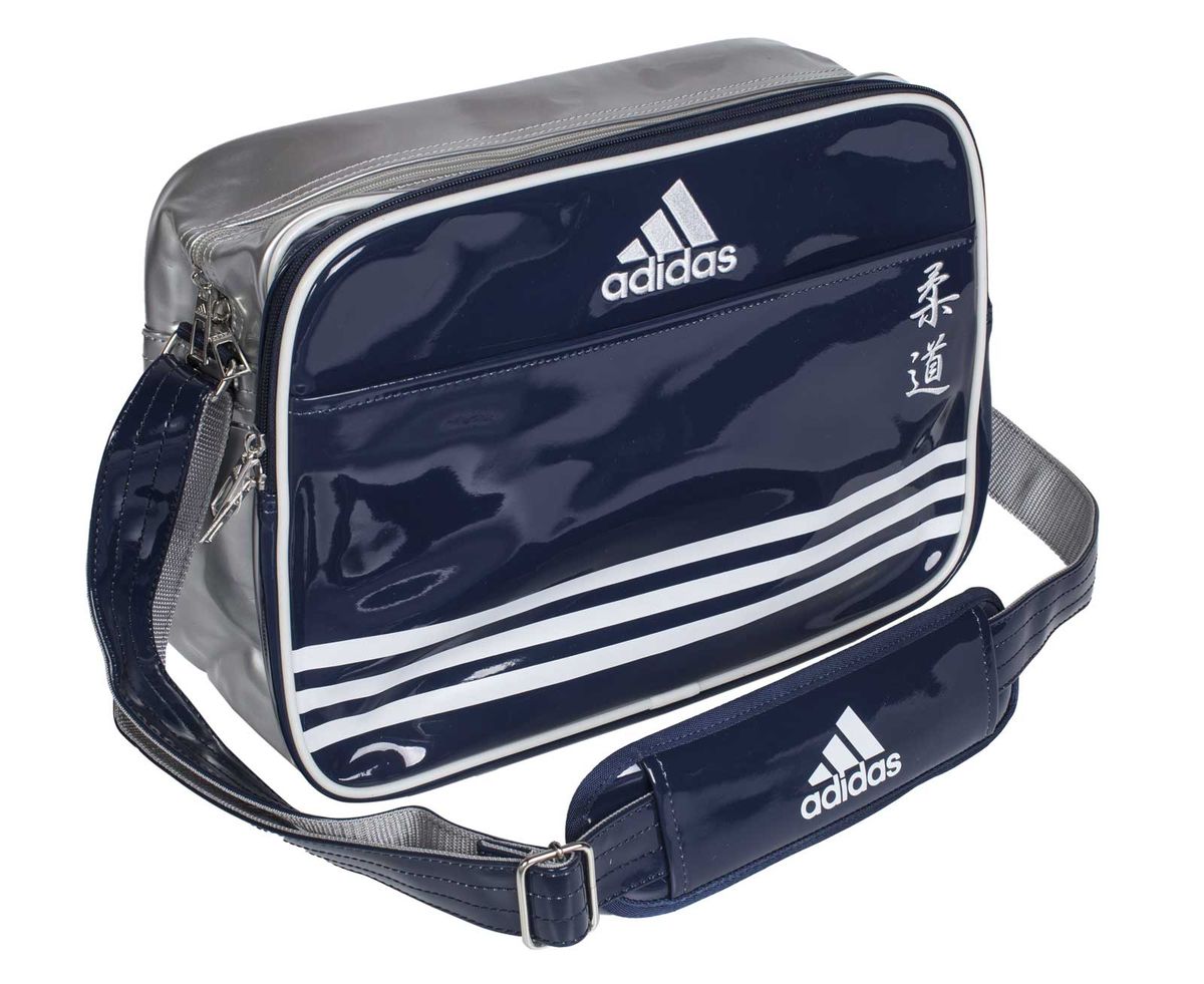 Сумка спортивная Adidas Sports Carry Bag Judo, цвет: синий, серебристый, белый. Размер SS76245 Сумка спортивная Adidas Sports Carry Bag Judo, цвет: синий, серебристый, белый. Размер SS76245Спортивная сумка Adidas Sports Carry Bag Judo изготовлена из искусственной кожи. На передней стороне сумки вышиты иероглифы Judo. Она предназначена для переноски и хранения спортивного инвентаря и других нужных для занятия спортом предметов. Сумка состоит из 1 большого отделения и 2 внешних карманов. Имеет удобный плечевой ремень.