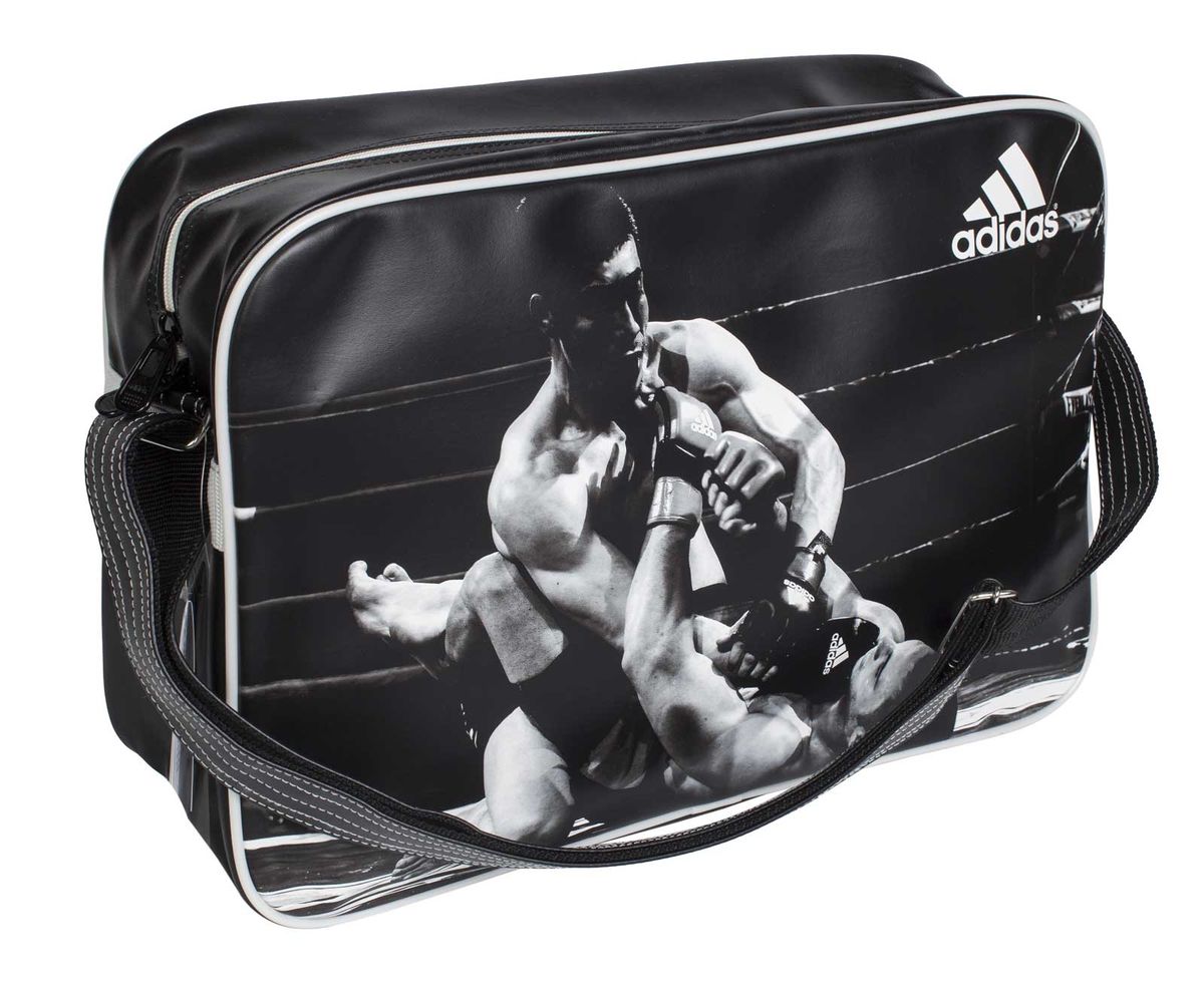 Сумка спортивная Adidas Sports Bag MMA, цвет: черный, белый. Размер L1904508 Сумка спортивная Adidas Sports Bag MMA, цвет: черный, белый. Размер L1904508Спортивная сумка Adidas Sports Bag MMA изготовлена из искусственной кожи. Лицевая сторона сумки оформлена оригинальным принтом. Она предназначена для переноски и хранения спортивного инвентаря и других нужных для занятия спортом предметов. Сумка состоит из 1 большого отделения. Имеет удобный плечевой ремень.