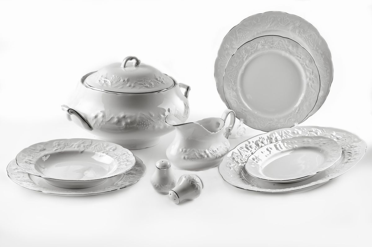 Сервиз столовый La Rose des Sables Vendanges Platine, 25 предметов115510 Сервиз столовый La Rose des Sables Vendanges Platine, 25 предметов115510Сервиз столовый La Rose des Sables Vendanges Platine состоит из 6 обеденных тарелок, 6 десертных тарелок, 6 суповых тарелок, салатника, 2 овальных блюд, супницы с крышкой, соусника, солонки и перечницы. Посуда выполнена из высококачественного тунисского фарфора, изготовленного из уникальной белой глины. На всех изделиях La Rose des Sables можно увидеть маркировку Pate de Limoges. Это означает, что сырье для изготовления фарфора добывают во французской провинции Лимож, и качество соответствует высоким европейским стандартам. Все производство расположено в Тунисе. Особые свойства этой глины, открытые еще в 18 веке, позволяют создать удивительно тонкую, легкую и при этом прочную посуду. Благодаря двойному термическому обжигу фарфор обладает высокой ударопрочностью, стойкостью к сколам и трещинам, жаропрочностью и великолепным блеском глазури. Коллекция Vendanges Platine - это изысканная классика, дополненная нежным рельефом в виде гроздей винограда и платиновой эмалью. Эта белая фарфоровая посуда станет настоящим украшением вашего стола. Прекрасный вариант как для праздничной, так и для повседневной сервировки стола. Не рекомендуется использовать в СВЧ печи и мыть в посудомоечной машине. Диаметр десертной тарелки: 21 см. Диаметр обеденной тарелки: 26 см. Диаметр суповой тарелки: 22 см. Диаметр салатника: 25 см. Размер овальных блюд: 24 см; 36 см. Объем супницы: 3,5 л. Объем соусника: 450 мл.