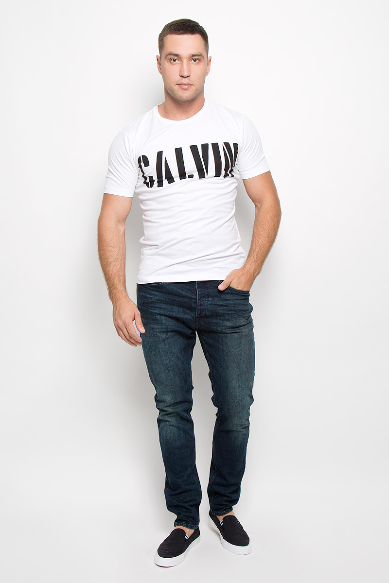 Футболка мужская Calvin Klein Jeans, цвет: молочный. J30J300139_1120. Размер XXL (54/56)R0216Т11 Футболка мужская Calvin Klein Jeans, цвет: молочный. J30J300139_1120. Размер XXL (54/56)R0216Т11Стильная мужская футболка Calvin Klein Jeans, выполненная из эластичного хлопка, обладает высокой теплопроводностью, воздухопроницаемостью и гигроскопичностью. Она необычайно мягкая и приятная на ощупь, не сковывает движения и превосходно пропускает воздух. Такая футболка отлично подойдет как для занятия спортом, так и для повседневной носки.Модель с короткими рукавами и круглым вырезом горловины - идеальный вариант для создания модного современного образа. Футболка оформлена крупным контрастным принтом с надписью Calvin. Эта модель подарит вам комфорт в течение всего дня и послужит замечательным дополнением к вашему гардеробу.
