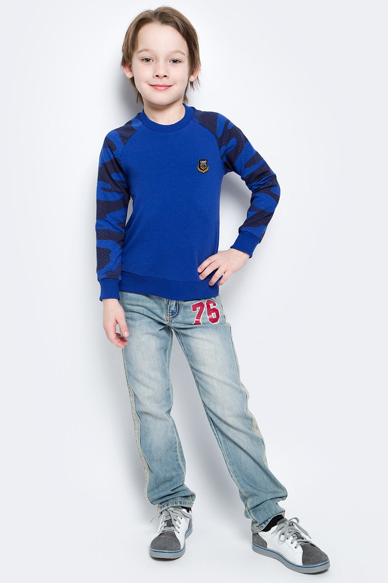 Свитшот для мальчика M&D, цвет: синий, черный. SJK17001M29. Размер 110SJK17001M29/SJK17001S29 Свитшот для мальчика M&D, цвет: синий, черный. SJK17001M29. Размер 110SJK17001M29/SJK17001S29Стильный свитшот для мальчика M&D выполнен из высококачественного хлопка с добавлением лайкры. Свитшот с длинными рукавами и круглым вырезом горловины оформлен на груди оригинальным декоративным элементом. Низ, горловина и рукава изделия дополнены трикотажной резинкой.